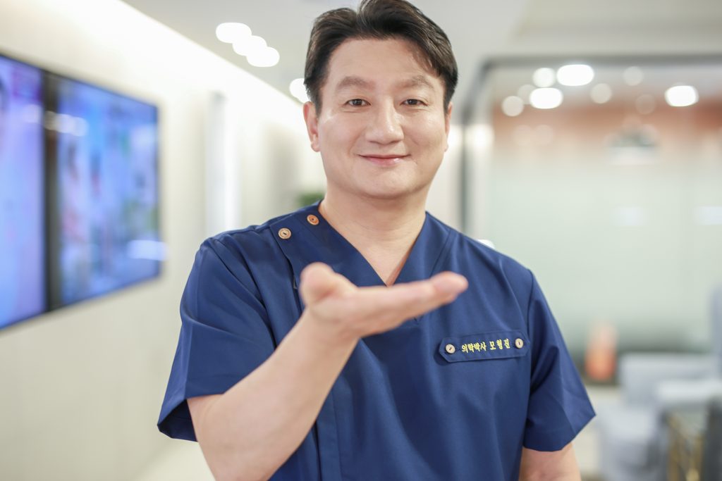 Portrait of Dr. Mo Hyung-jin, medical director, in navy scrubs